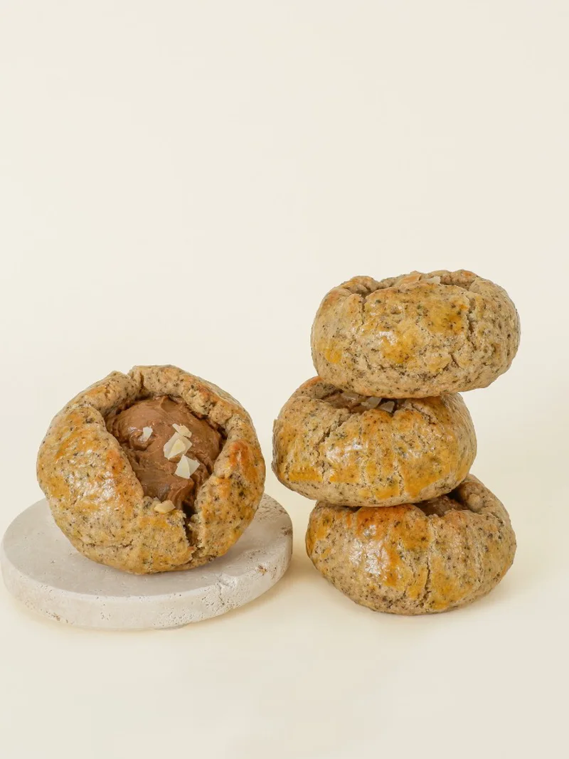 Four Earl Grey scones, the dough flecked with tea leaves — one open on a stone coaster to show the cream cheese centre, three stacked.